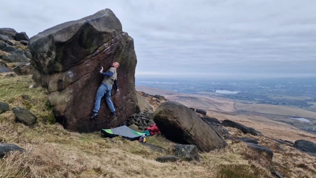 A picture of me climbing Concavity Cons Gravity in March 2025 at Blackstone Edge.